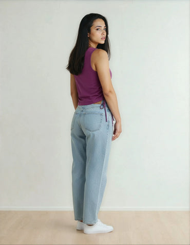 Femme en débardeur violet et jean clair tendance, intérieur minimaliste, 974 Réunion