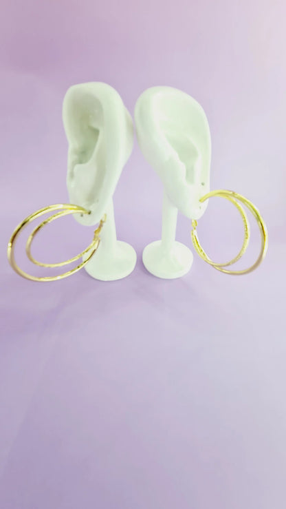 Créoles dorées pour femme sur présentoir oreilles, fond violet, 974 Réunion tendance