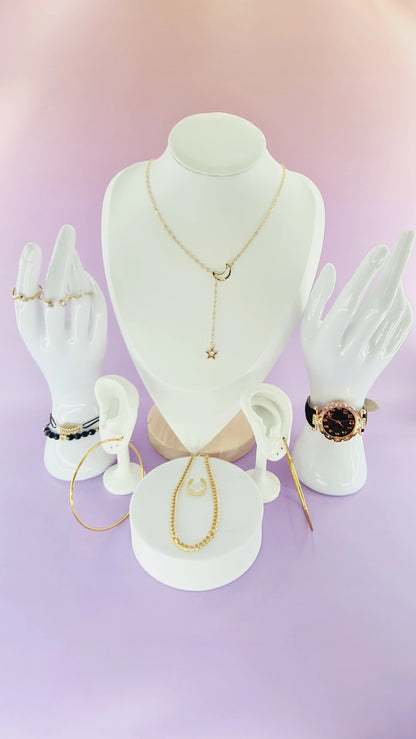 Présentation bijoux femme 974 reunion : collier lune, montre dorée, bagues, bracelets sur fond violet.