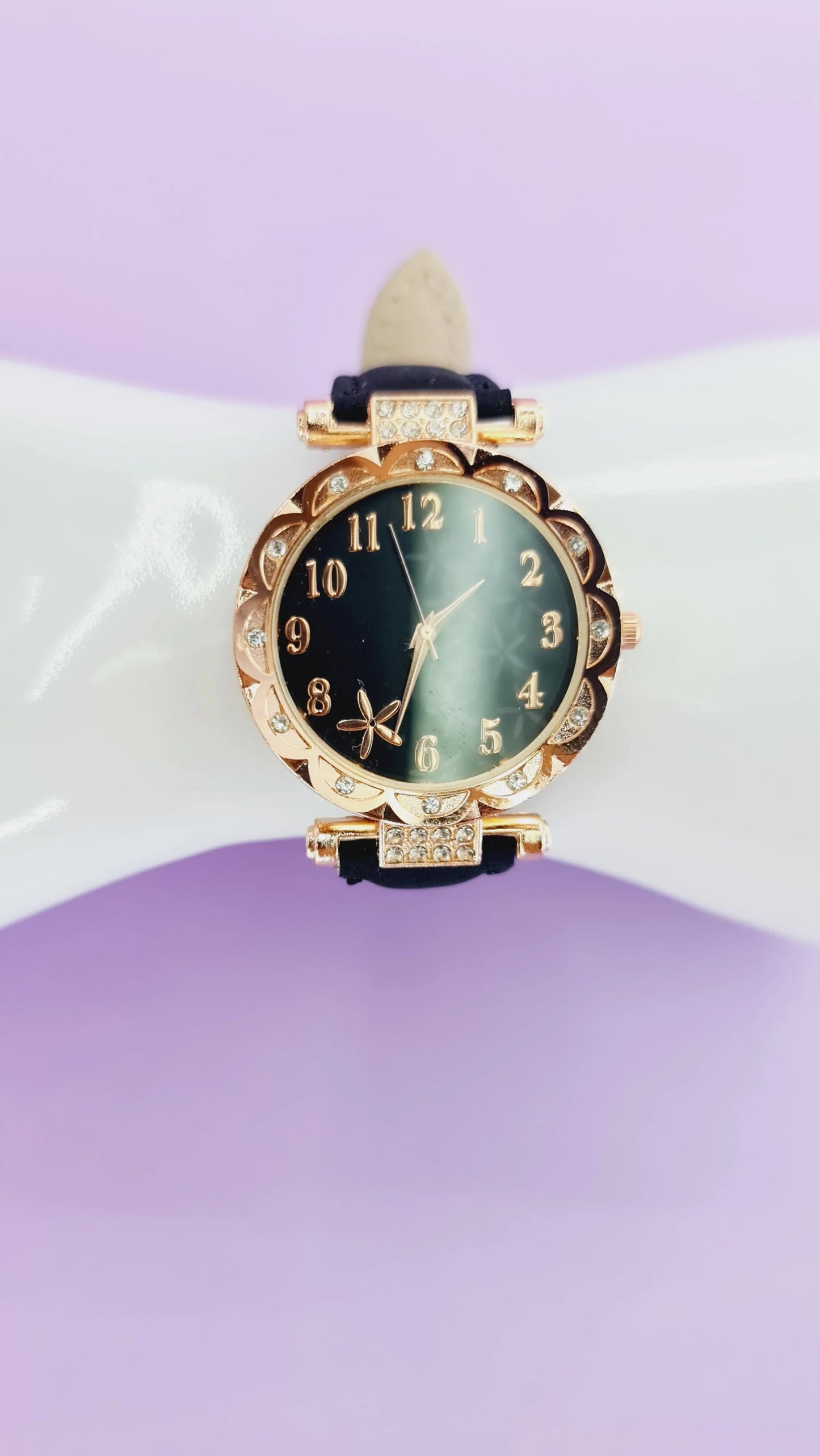 Montre femme dorée cadran noir et strass, bracelet noir, mode 974 Réunion, fond violet.