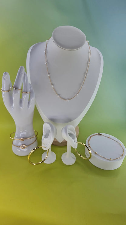 parures bijoux dorés femme, colliers, boucles d’oreilles, bracelets sur présentoir, 974 Reunion