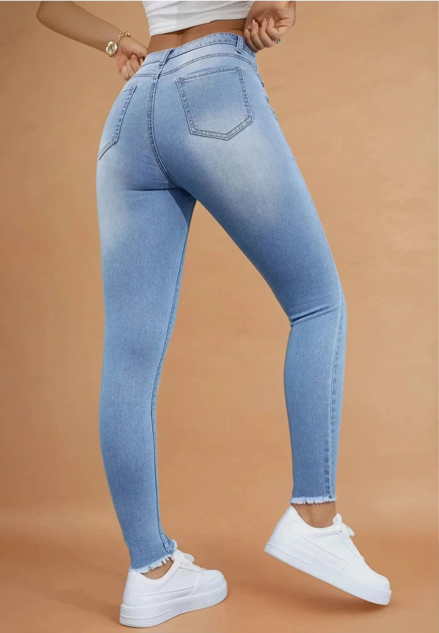 Jean moulant femme bleu clair 974 Réunion, sneakers blanches, fond beige