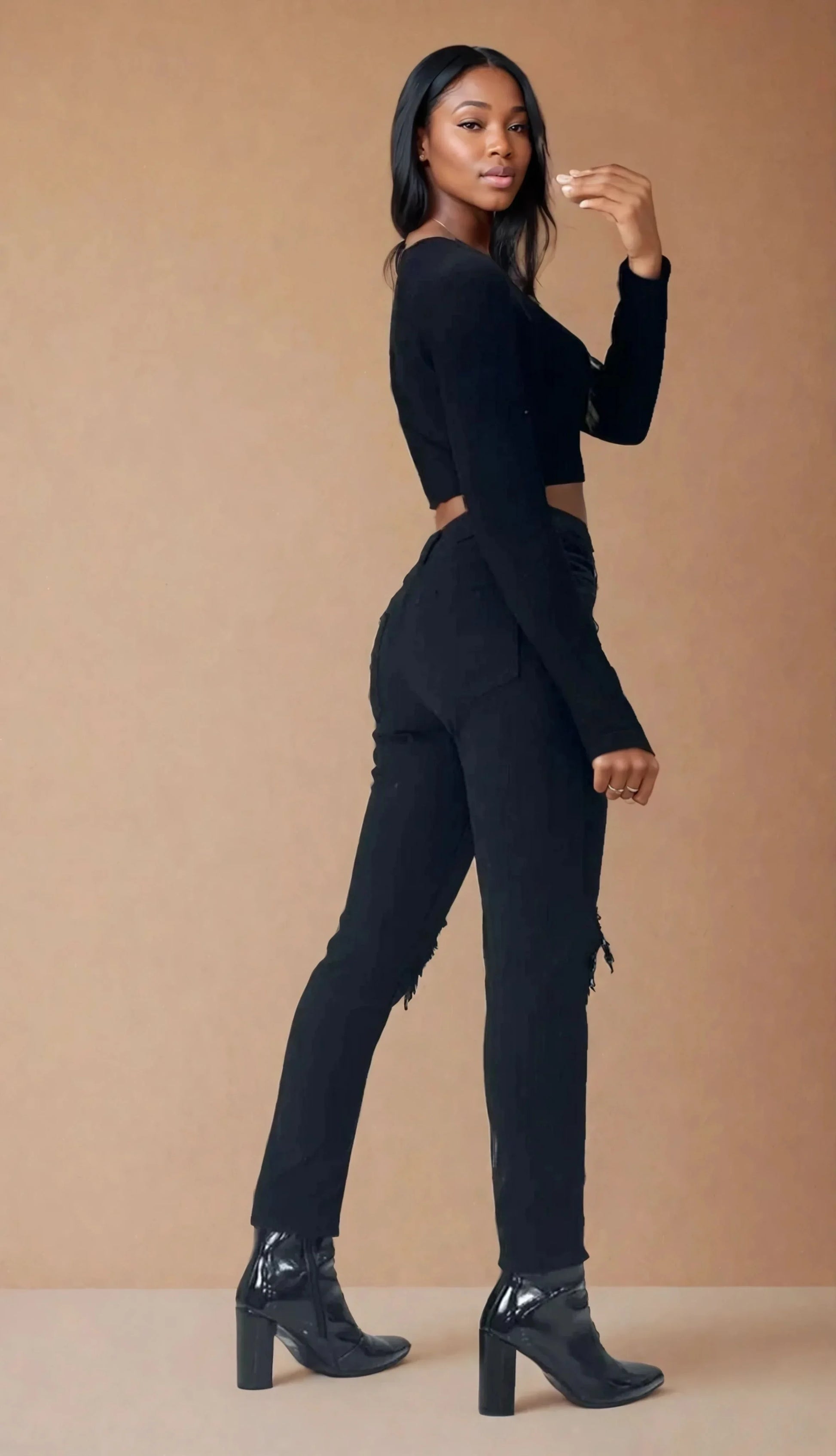 Femme portant un jean slim noir effet destroy, tendance 974 Réunion, bottines à talons.