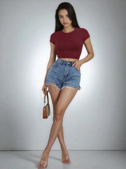 Femme portant un crop top bordeaux et un short en jean tendance été 974 Réunion