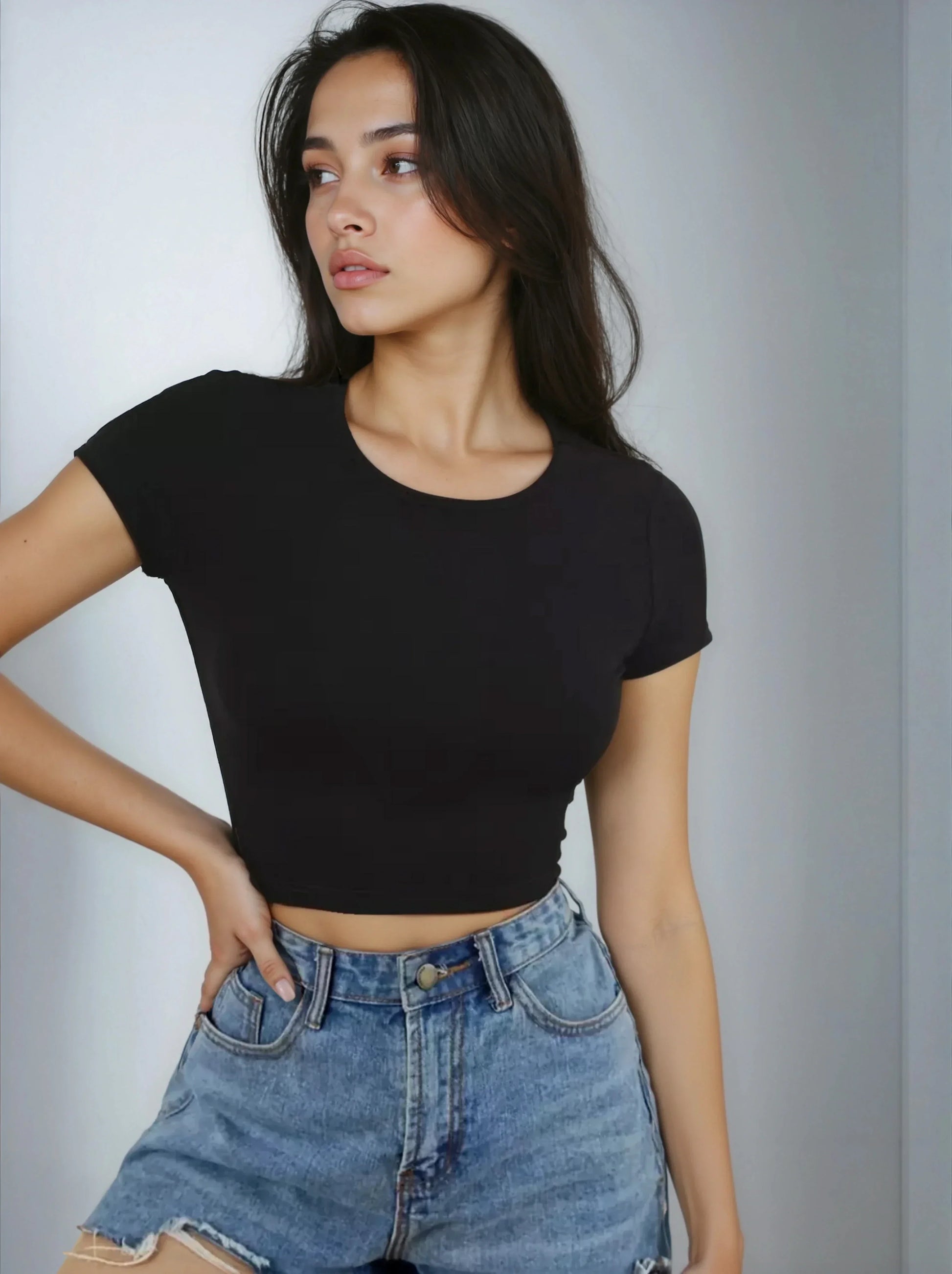 Femme portant un crop top noir et un short en jean, mode tendance 974 Réunion