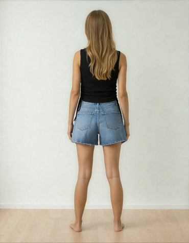 Femme de dos en short en jean et débardeur noir, style tendance 974 Réunion