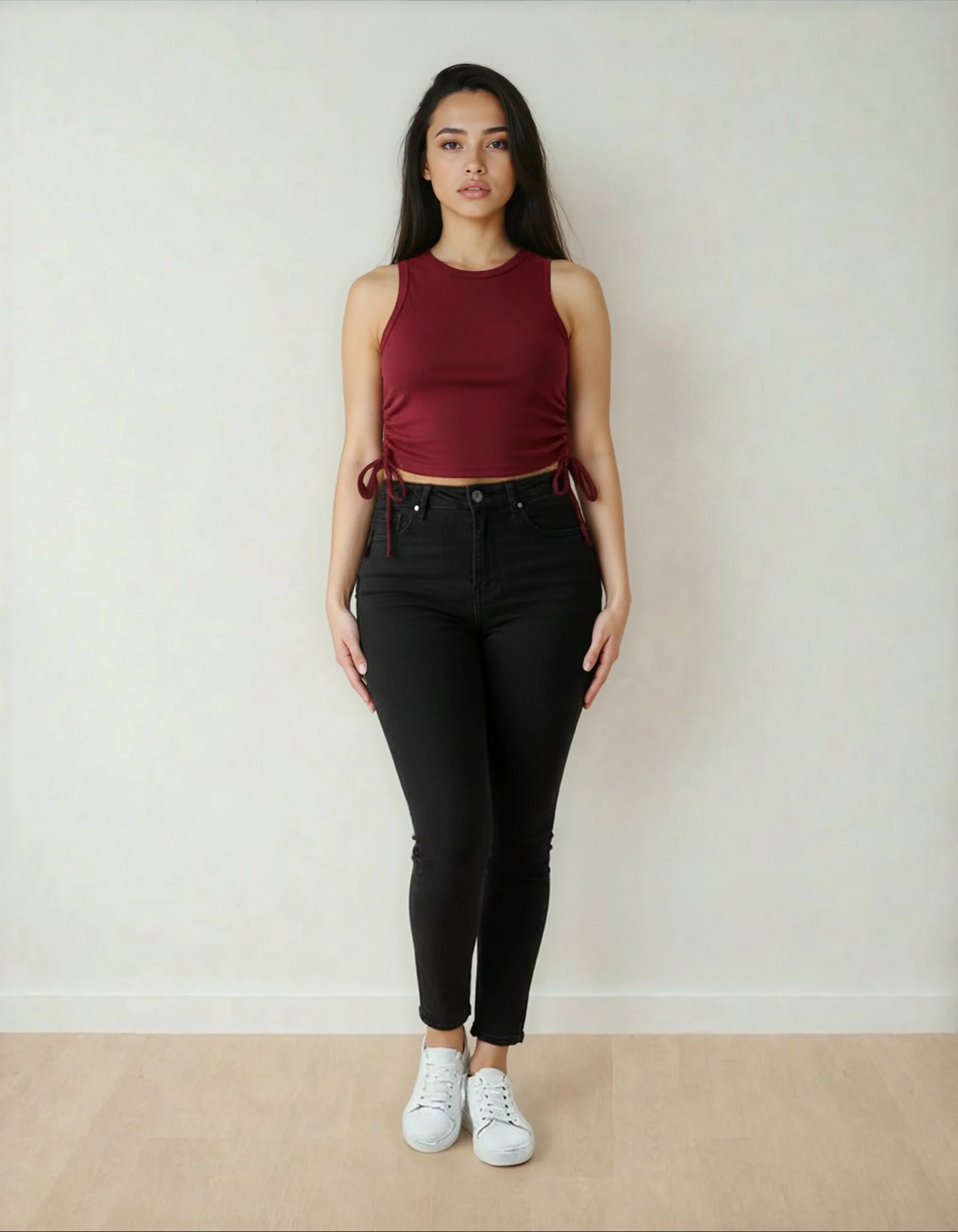 Femme debout, portant un crop top bordeaux et un pantalon noir, mode tendance 974 Réunion