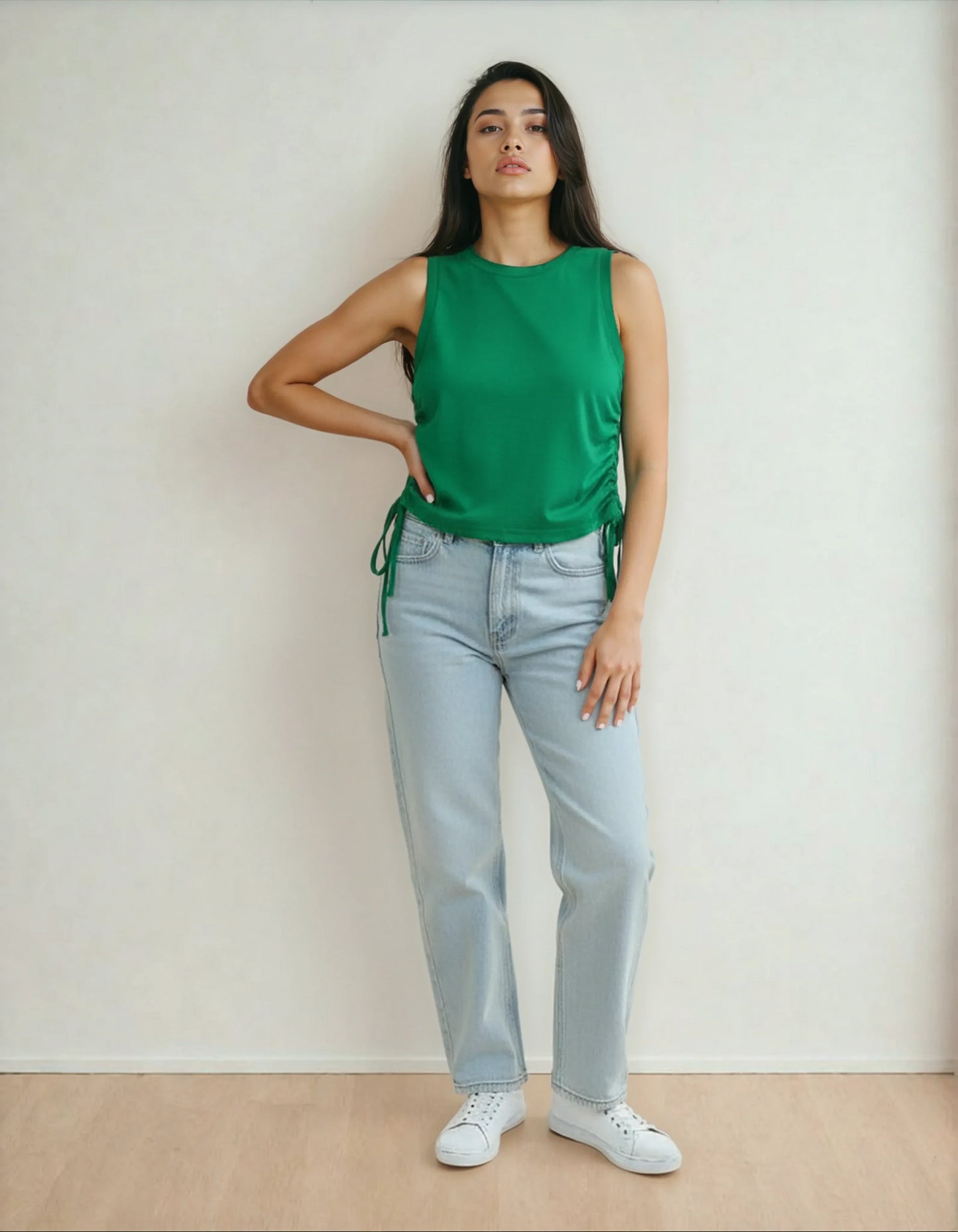 Femme en débardeur vert et jean clair, mode tendance 974 Réunion, pose sur parquet